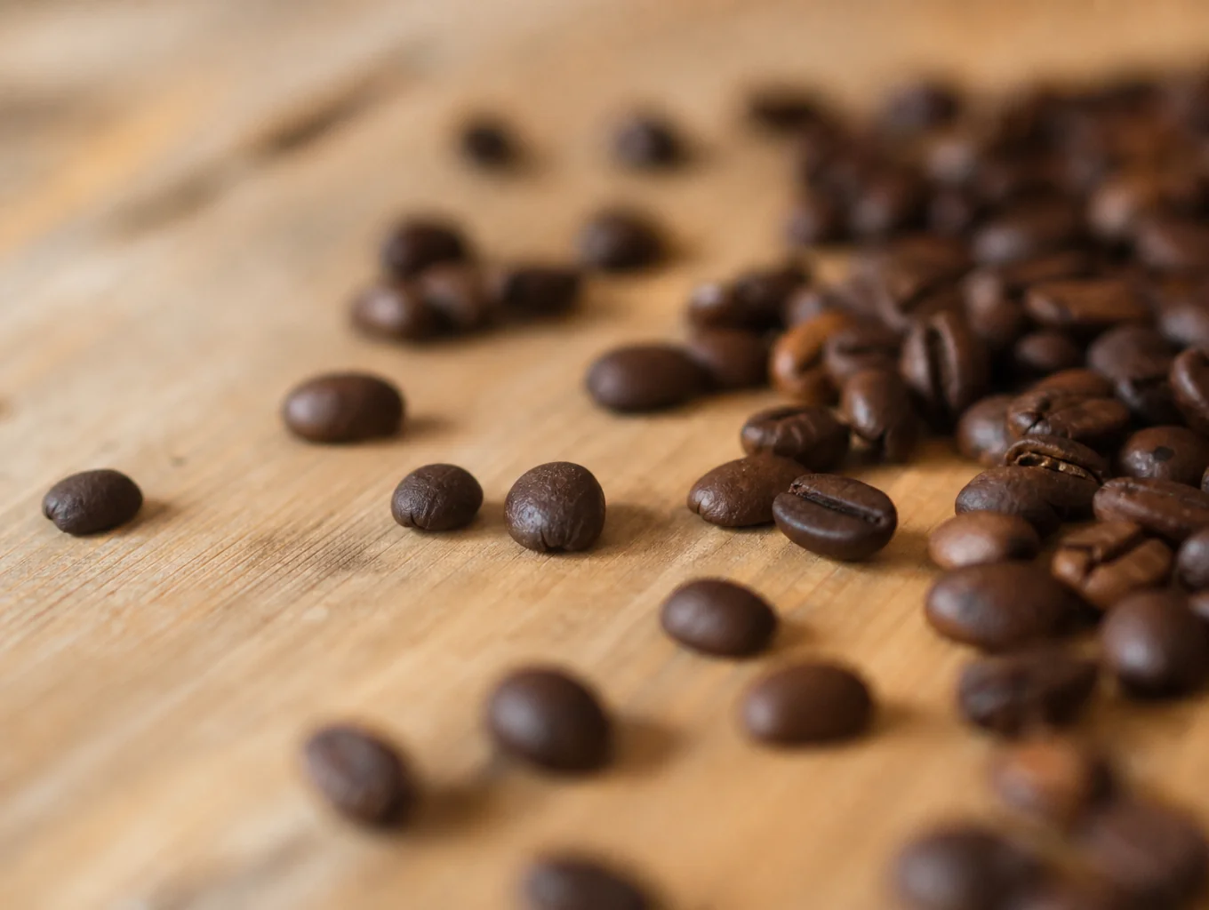 Close up of roasted coffee beans on a wooden table